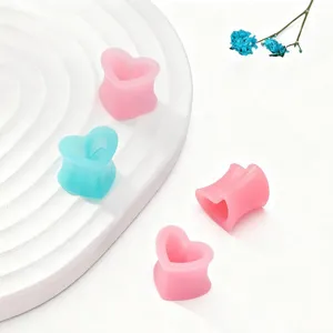 Gros plan détaillé de bouchons d'oreilles en silicone en forme de cœur et bijoux de corps.