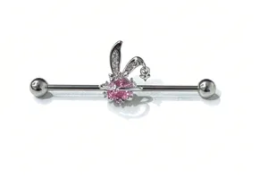 Detail of industrial piercing barbell with pink crystal stone and rhinestone bunny ear charm.
