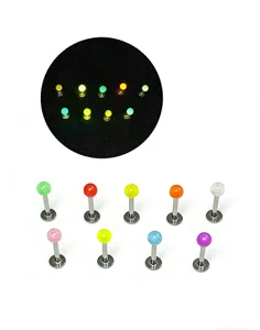 Detailed view of glow in the dark lip piercing jewelry with stainless steel bars and colorful acrylic balls.