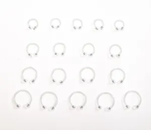 Close-up detail of clear acrylic horseshoe piercing rings, various sizes displayed neatly.