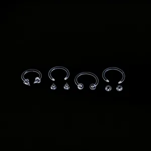 Clear acrylic horseshoe ring nose piercing jewelry set with spike and ball for body art.