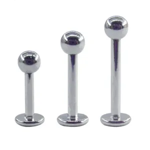Close-up detail of silver titanium labret piercing studs with flat back and round ball ends.