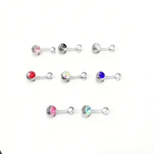 Close-up of colorful crystal belly button rings detail, stainless steel body piercing jewelry.