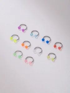 Detailed shot of stainless steel horseshoe piercing rings with colorful acrylic balls, septum jewelry.