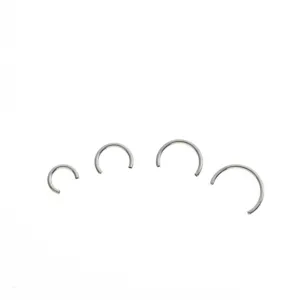 Close-up detail of G23 titanium horseshoe piercing rings in multiple sizes for body jewelry.