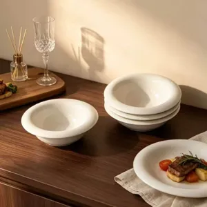 Primer plano de plato llano de cerámica blanca de ala ancha, estilo francés minimalista.
