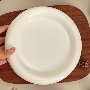 Assiette plate en céramique blanche, bord rond épais, style moderne minimaliste pour la maison.