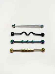 Detailed view of four colorful stainless steel industrial piercing barbells with unique shapes.