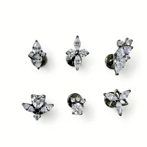Titanium body piercing jewelry details, sparkling cubic zirconia crystal stud cluster designs.