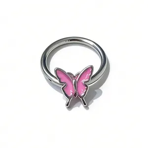 Detailed close-up of a silver body piercing ring featuring a cute pink enameled butterfly charm.