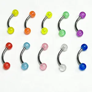Close-up detail of stainless steel curved barbell body piercing jewelry with colorful acrylic balls.