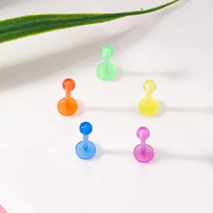 Detail shot of colorful acrylic labret studs arranged neatly on a clean white surface.