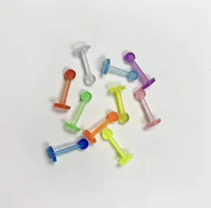Close-up details of colorful translucent acrylic labret studs body piercing jewelry items.