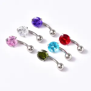 Gros plan détaillé de piercings de nombril en acier inoxydable avec zircons colorés.