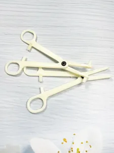 Detailed view of white plastic body piercing opening closing pliers tool for safe piercing use.