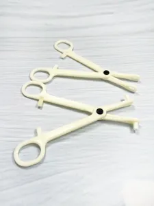 Acrylic piercing closing tool detail, body modification auxiliary plier in beige color.