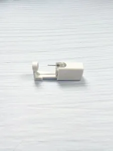 Disposable ear piercing tool detail view, safe body piercing device in white plastic.