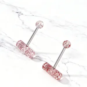 Detailed closeup of T-shaped capsule tongue ring, stainless steel shaft, pink glitter acrylic.