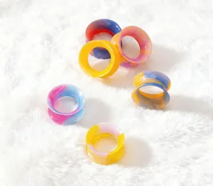 Colorful silicone ear tunnels close-up view, flexible double flare body piercing jewelry detail.
