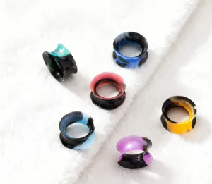 Close-up view of colorful silicone ear tunnels, showing vibrant dual-color texture details.