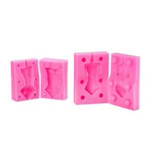 Vue en gros plan du moule de corps en silicone, moule de poupée en argile rose avec broches.