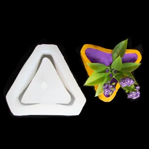 Geometric triangle silicone mold detail view showing the white mold and potted plant.
