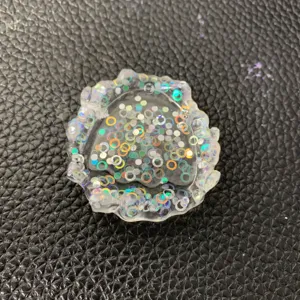 Nahaufnahme Detail der unregelmässigen transparenten Harzschale mit holografischen Glitzerpunkten.