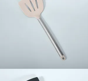 Silicone slotted spatula detail, heat resistant cooking utensil with stainless steel handle.