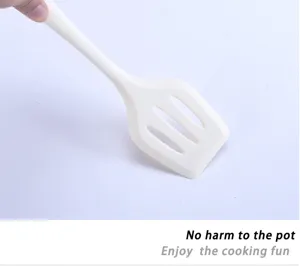 White silicone slotted spatula detail, heat-resistant kitchen cooking tool for non-stick pan.