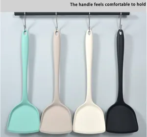Silicone kitchen spatula close-up hanging on rack, flexible cooking utensil in multi colors.