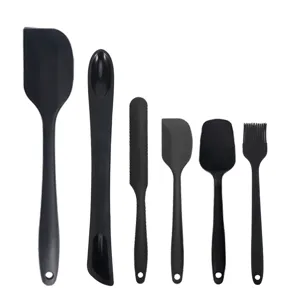 Primo piano del set di spatole da cucina in silicone nero, 6 pezzi con fori per appenderle.