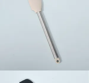 Silicone spatula detail view, stainless steel handle close up, kitchen baking tool detail.