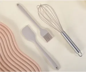 Gros plan sur les détails du set d'ustensiles de cuisine en silicone avec fouet et pinceau.