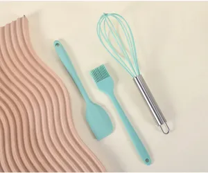 Ensemble d'ustensiles de patisserie en silicone vert, spatule, pinceau et fouet de cuisine.