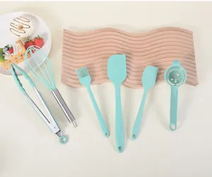 Silicone kitchen utensils set detail showing mint green spatulas, whisk, and food tongs.