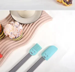 Silicone spatula and brush detail shot, cute face design, perfect for baking and baby food.