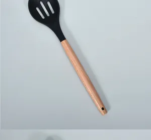Silicone slotted spoon with solid wood handle, high temperature resistant cooking kitchen tool.