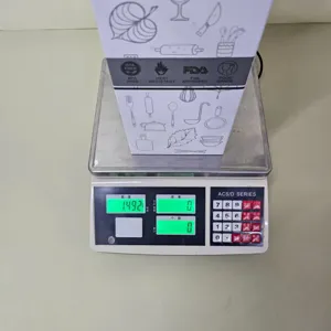 Caja de embalaje de utensilios de cocina de silueta en balanza digital mostrando el peso.