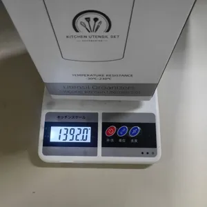 Detailansicht der Küchenutensilienzubehör-Verpackung und Gewichtsanzeige auf Waage.