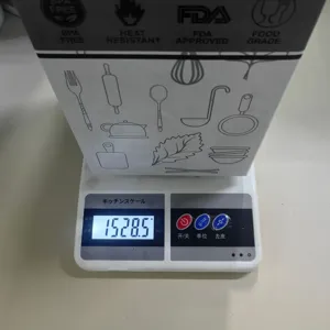 Detailed view of kitchen scale showing weight measurement with cooking utensils packaging.