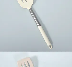 Dettaglio spatola forata in silicone, manico in acciaio inox resistente al calore.