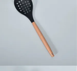 Large silicone slotted spoon with wooden handle heat resistant kitchen cooking tool detail view