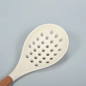 Large silicone slotted spoon with wooden handle, heat-resistant kitchen cooking colander tool.