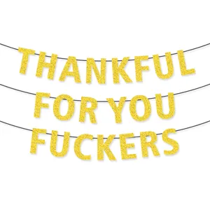 Close-up detail of the gold glitter party banner letters showing texture and hanging strings.