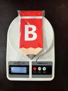 Detalle de la pieza de banderín escolar en forma de lápiz con la letra B para fiesta.