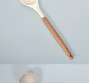 Silicone soup spoon with wooden handle, heat resistant kitchen tool detail view.