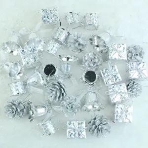 Silver Christmas tree ornaments detail, assorted miniature gift boxes and bells for holiday decor.