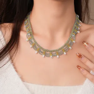 Gedetailleerde close-up van een meerlaagse kraal ketting met glasparels en elegante hangers.