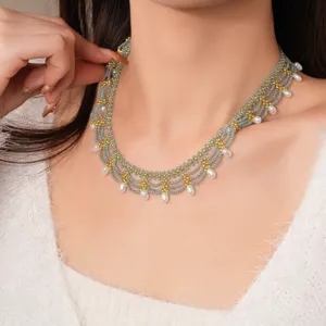 Handgemaakte meerstrengs glazen kraal choker halsketting met parelhangers en gouden accenten.
