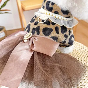 Dettaglio ravvicinato di elegante abito leopardato per animali con fiocco e perle.